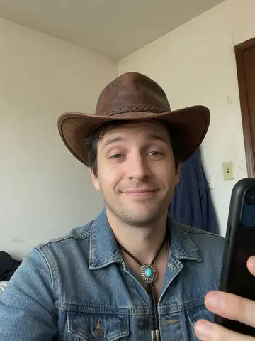Exempel på Cowboy-core: Personen bär en brun cowboyhatt, en jeansjacka och en bolo-slips.