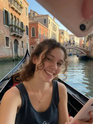 Exempel på Venedig: Personen sitter i en gondol på en kanal i Venedig med gamla färgglada hus och en bro bakom sig.